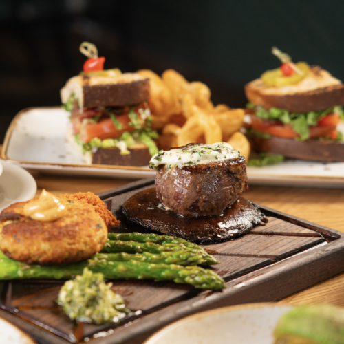 STEAK & CRAB CAKE ~ Petite filet, crabcake, asparagus, portobello mushroom, whipped potatoes, harissa, cilantro pesto and spicy Cajun aioli